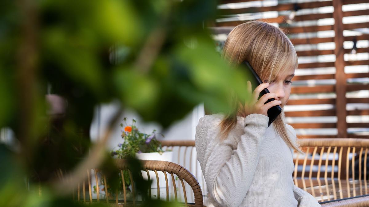 Ett barn med telefonen mot örat.