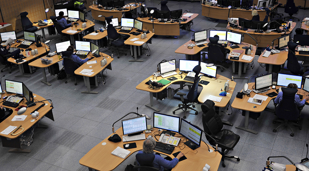 Kuva hätäkeskuksesta, missä hätäkeskuspäivystäjiä töissä työpöytiensä ääressä.