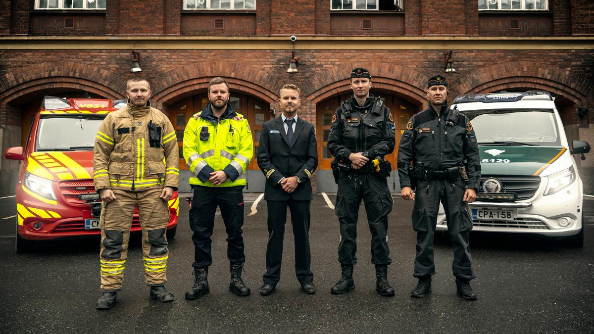 Kuvassa pelastustoimen sekä rajavartiolaitoksen edustajat ja hätäkeskuspäivystäjä virka-asussa paloaseman edessä.